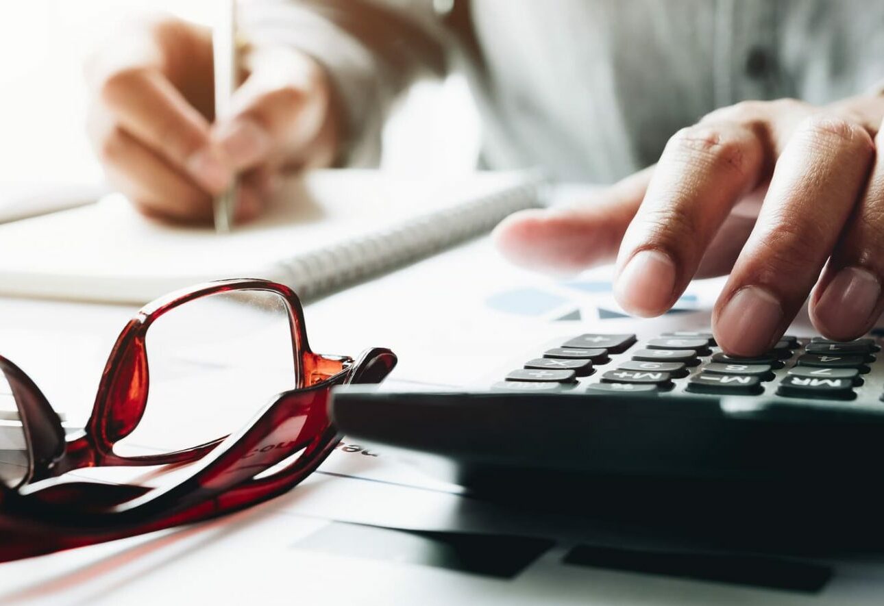 A person working out the costs of an adjustable bed on a calculator.