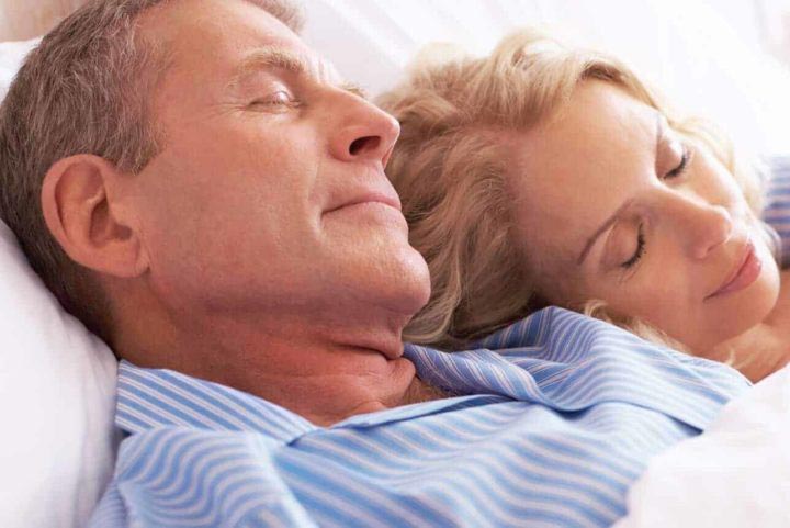 A couple asleep in their electric adjustable bed.